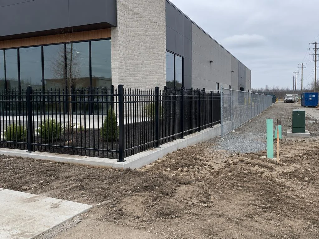 Ornamental aluminum and chain-link fencing along a commercial building lot